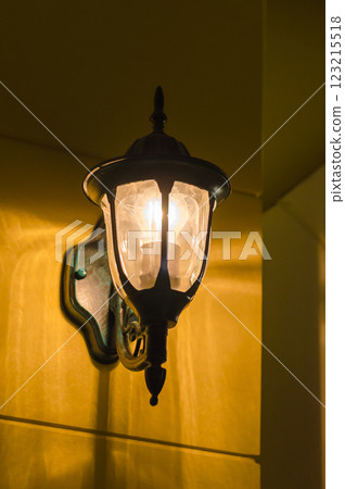 Wall-mounted lantern emitting warm light Wall-mounted lantern emitting warm light 123215518