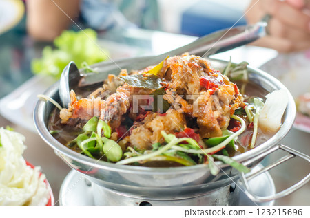 Delicious dish spicy sour soup and fried river fish served in a metal bowl 123215696