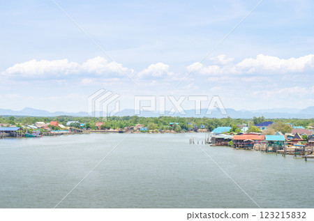 Serene waterfront with colorful houses and mountains. 123215832