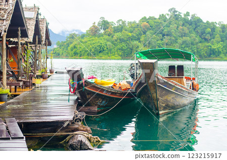 Scenic boats by lakeside cabins in lush landscape at Khao Sok national park at Surat Thani, Thailand 123215917