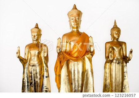 Three golden Buddha statues with orange robes at Wat Pho Bangkok Thailand 123216057