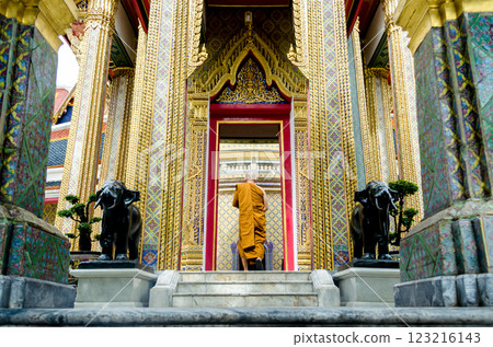 Ornate temple entrance with a monk walking in Wat Ratchabophit Bangkok Thailand Ornate temple entrance with a monk walking in Wat Ratchabophit Bangkok Thailand 123216143