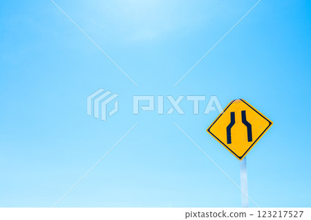 Blue sky and road narrowing warning sign and copy space Blue sky and road narrowing warning sign and copy space 123217527