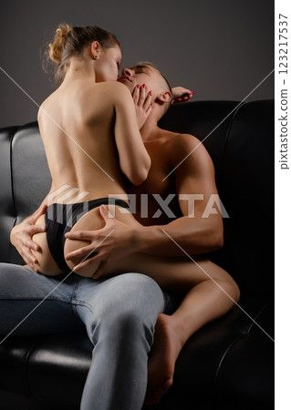 Couple sharing an intimate moment on a couch in a cozy setting Couple sharing an intimate moment on a couch in a cozy setting 123217537