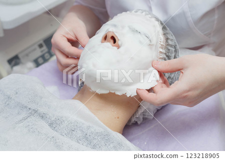 A cosmetologist does an ultrasonic cleaning of the skin of the face. 123218905