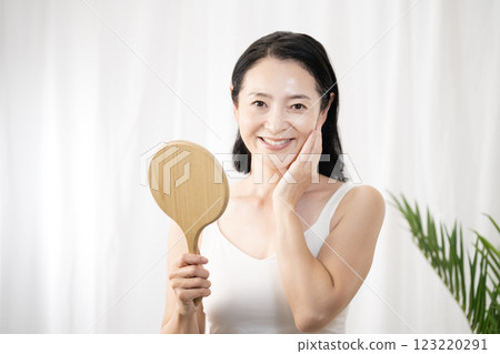 一位女士在做皮膚護理並揉搓臉頰 123220291