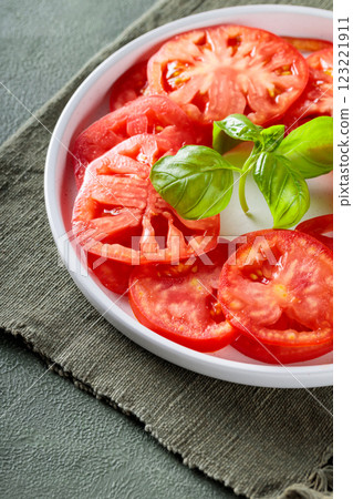 Salad Plate with Ripe Tomato Slices and Fresh Basil on Green Napkin, Close-Up Salad Plate with Ripe Tomato Slices and Fresh Basil on Green Napkin, Close-Up 123221911