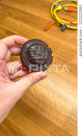 Hand Holding Chocolate Biscuit on Wooden Table Background. High quality photo 123222061