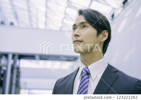 A young businessman in a suit looking up at the ceiling. Photo courtesy of Sky Perfect Tokyo Media Center 123222262