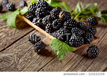Frash blackberries with leaves on a wooden table. Frash blackberries with leaves on a wooden table. 123222329