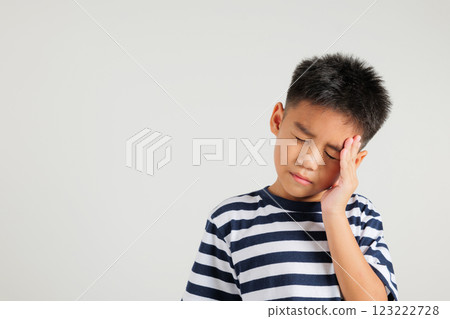 Portrait of Asian young kid boy sad tired strain face holding hold head by hands, stress primary child person unhappy closed eyes problem headache, studio shot isolated on white background 123222728