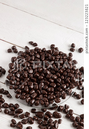 Dried fruits and berries in brown chocolate glaze. Candies on a white wooden background. Dried fruits and berries in brown chocolate glaze. Candies on a white wooden background. 123223821