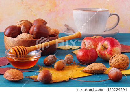 Blue wooden table with apples, nuts, chestnuts and honey Blue wooden table with apples, nuts, chestnuts and honey 123224594
