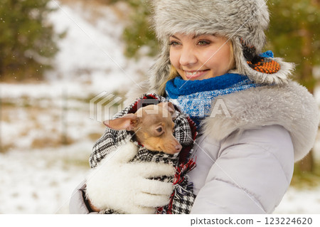 Woman hug warming her little dog in winter Woman hug warming her little dog in winter 123224620