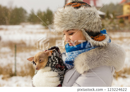 Woman hug warming her little dog in winter Woman hug warming her little dog in winter 123224622