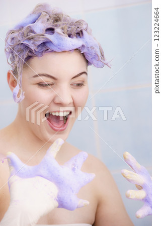 Woman applying toner shampoo on her hair Woman applying toner shampoo on her hair 123224664