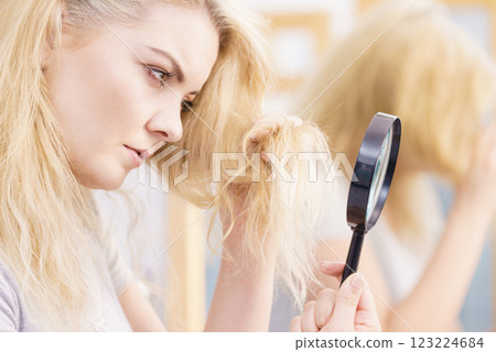 Woman magnifying her split ends hair 123224684