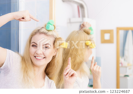 Blonde woman using hair rollers 123224687
