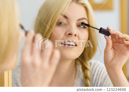 Woman using mascara on her eyelashes Woman using mascara on her eyelashes 123224698