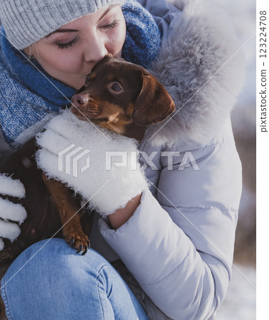 Woman playing with dog during winter 123224708
