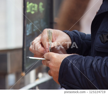 Person counting money at an outdoor market transaction Person counting money at an outdoor market transaction 123224719