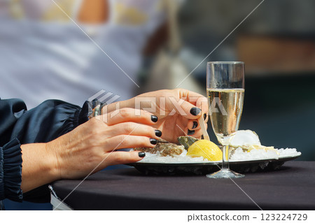 Elegant Woman Enjoying Oysters and Champagne at outdoor market 123224729