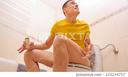 Man sitting on toilet discovering no toilet paper Man sitting on toilet discovering no toilet paper 123224757