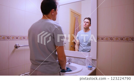 Depressed man preparing for work in bathroom mirror 123224790