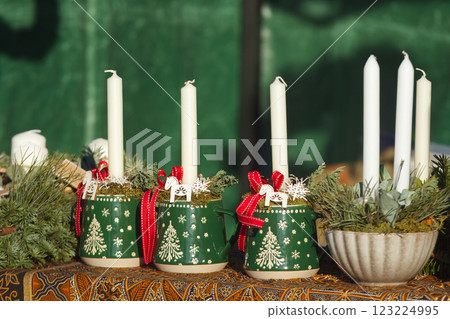 Candlesticks decorated with Christmas motifs in a stand at the farmers market Candlesticks decorated with Christmas motifs in a stand at the farmers market 123224995