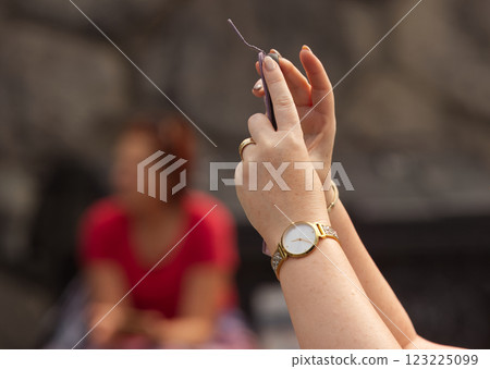 Womens hands taking photos with a smartphone at the marketplace in Prague Womens hands taking photos with a smartphone at the marketplace in Prague 123225099