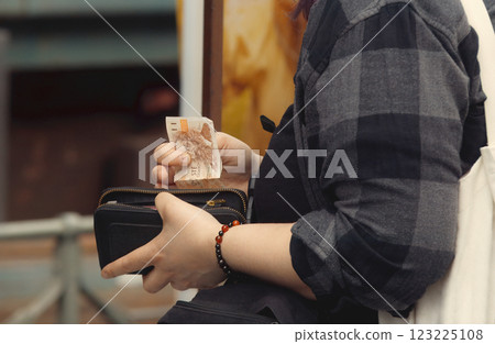 A customer, holding wallet and money and paying at outdoor farmers market 123225108