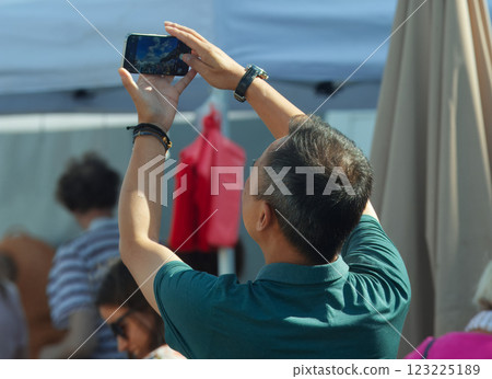 An unrecognizable person photographing the action at the street in Prague. 123225189