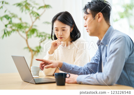 一對夫婦一邊看著電腦顯示器一邊聊天 123226548