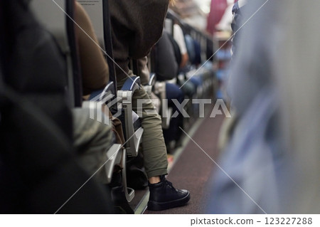 Passengers sit along the row in the plane in their seats. The concept of travel. High quality photo 123227288