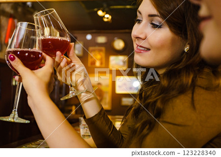 Two friends toasting with wine glasses at pub. 123228340