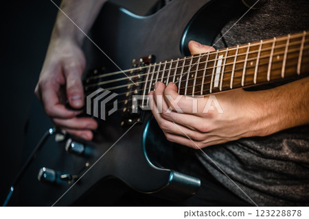 Male hands playing electric guitar 123228878