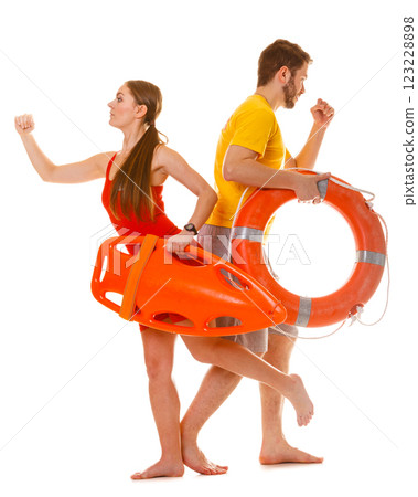 Lifeguards running with rescue ring buoy on duty. Lifeguards running with rescue ring buoy on duty. 123228898