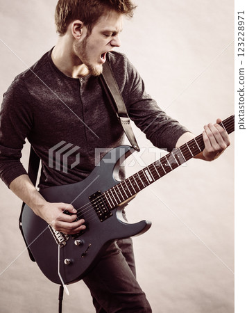 Young man playing electric guitar Young man playing electric guitar 123228971