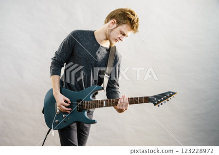 Young man playing electric guitar Young man playing electric guitar 123228972