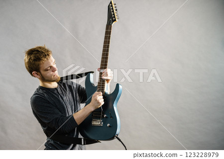 Young man playing electric guitar 123228979