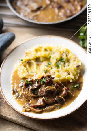 Roasted Pork Neck with mashed potatoes and mushroom sauce on a plate Roasted Pork Neck with mashed potatoes and mushroom sauce on a plate 123229359