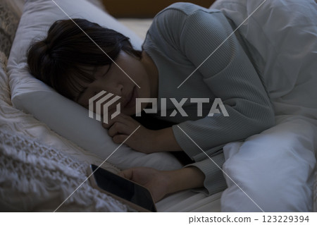 A woman watching a smartphone in bed 123229394