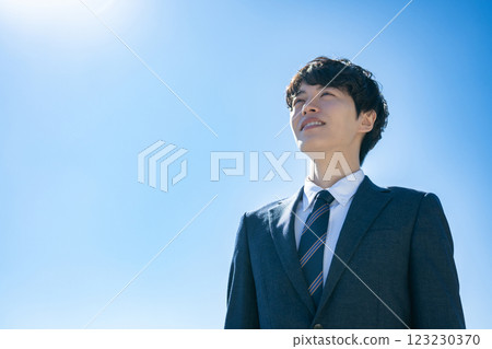 一名身著西裝的男子麵朝天空站立 一名身著西裝的男子麵朝天空站立 123230370