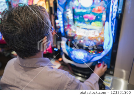 Man playing pachinko Man playing pachinko 123231500