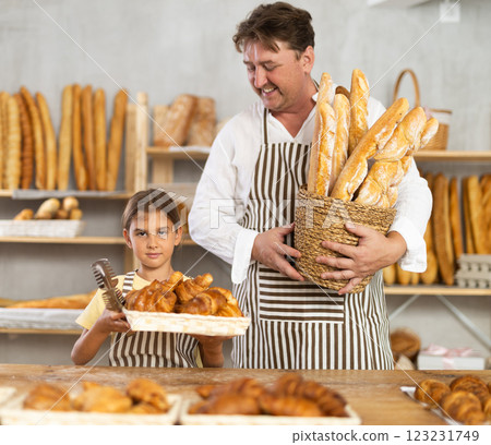 Baker dad and daughter are standing near product range in bakery kitchen. 123231749