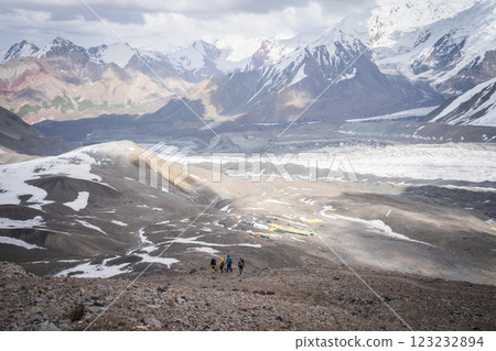 Group of mountaineers descending back to camp surrounded by magnificent alpine landscape of Pamir 123232894