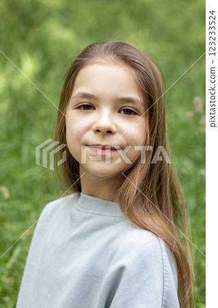 Portrait of a young girl outdoors in a natural green environment Portrait of a young girl outdoors in a natural green environment 123233524