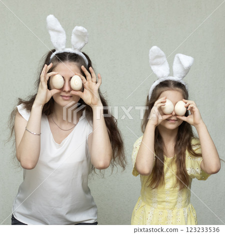 Two women posing with Easter decorations and bunny ears in a playful setting 123233536