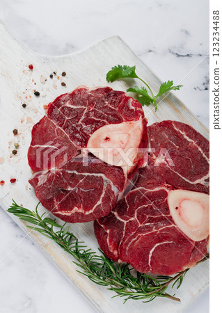 knuckle on the bone, raw meat for ossobuco, on a wooden chopping board, with a sprig of rosemary, and spices, top view, no people, knuckle on the bone, raw meat for ossobuco, on a wooden chopping board, with a sprig of rosemary, and spices, top view, no people, 123234488