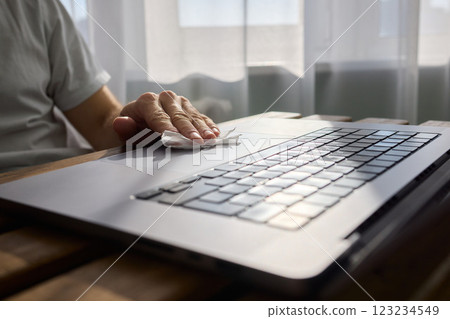Meticulously Hand Cleaning Your Laptop with a Tissue to Achieve a Fresh and Neat Workspace Meticulously Hand Cleaning Your Laptop with a Tissue to Achieve a Fresh and Neat Workspace 123234549